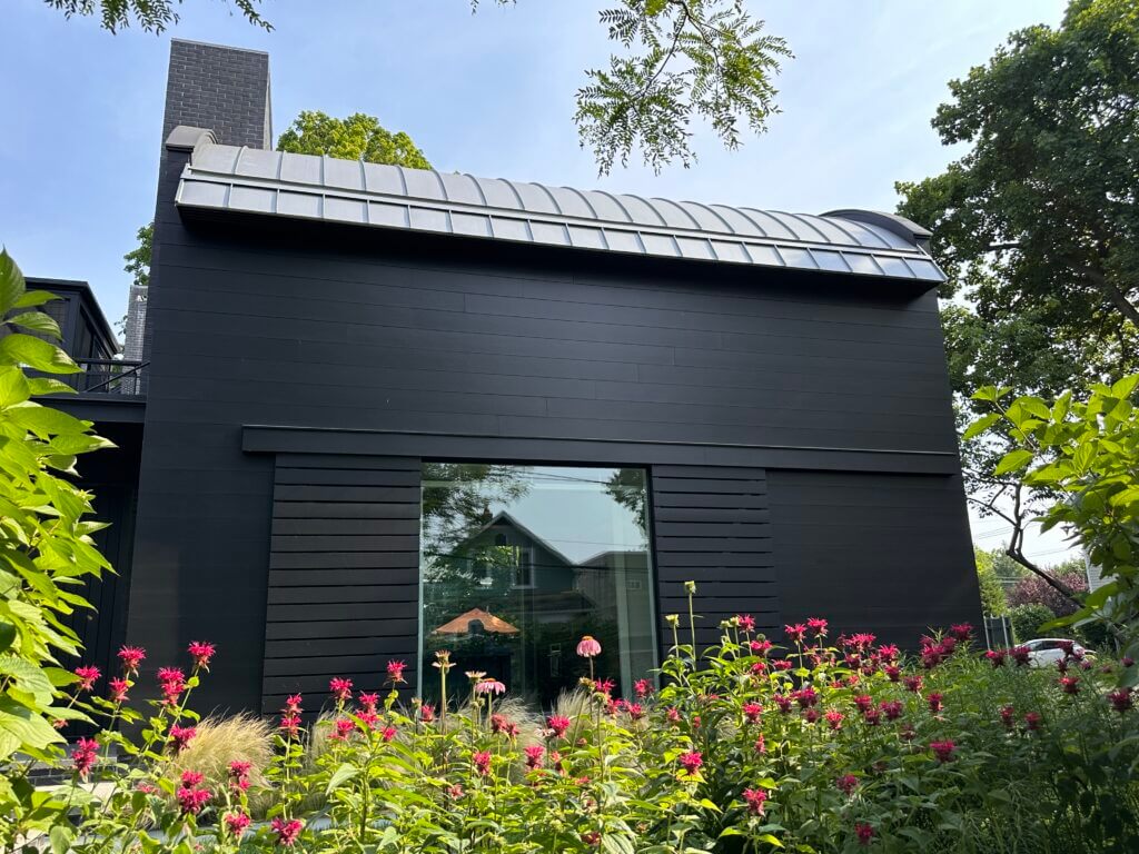 Plantings around a modern black home from a landscape design by Landbox Landscape Architecture Studio